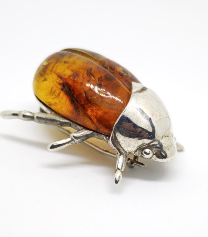 Broche Distintivo Elaborado en Plata de Ley 925, con Forma de Escarabajo y Ambar Natural.